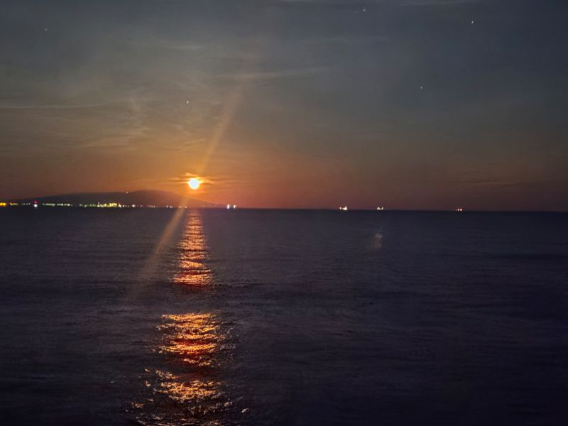 朝日のように赤く光る幻想的な月とムーンロード　遠くには伊豆大島の街あかりや漁火をご覧いただけます